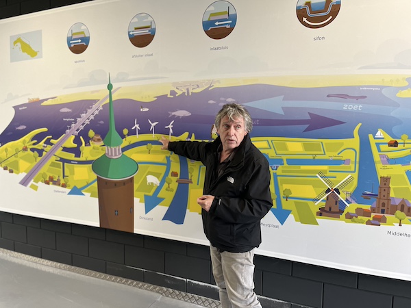 Kees Stoutjesdijk geeft uitleg bij een grote tekening. 