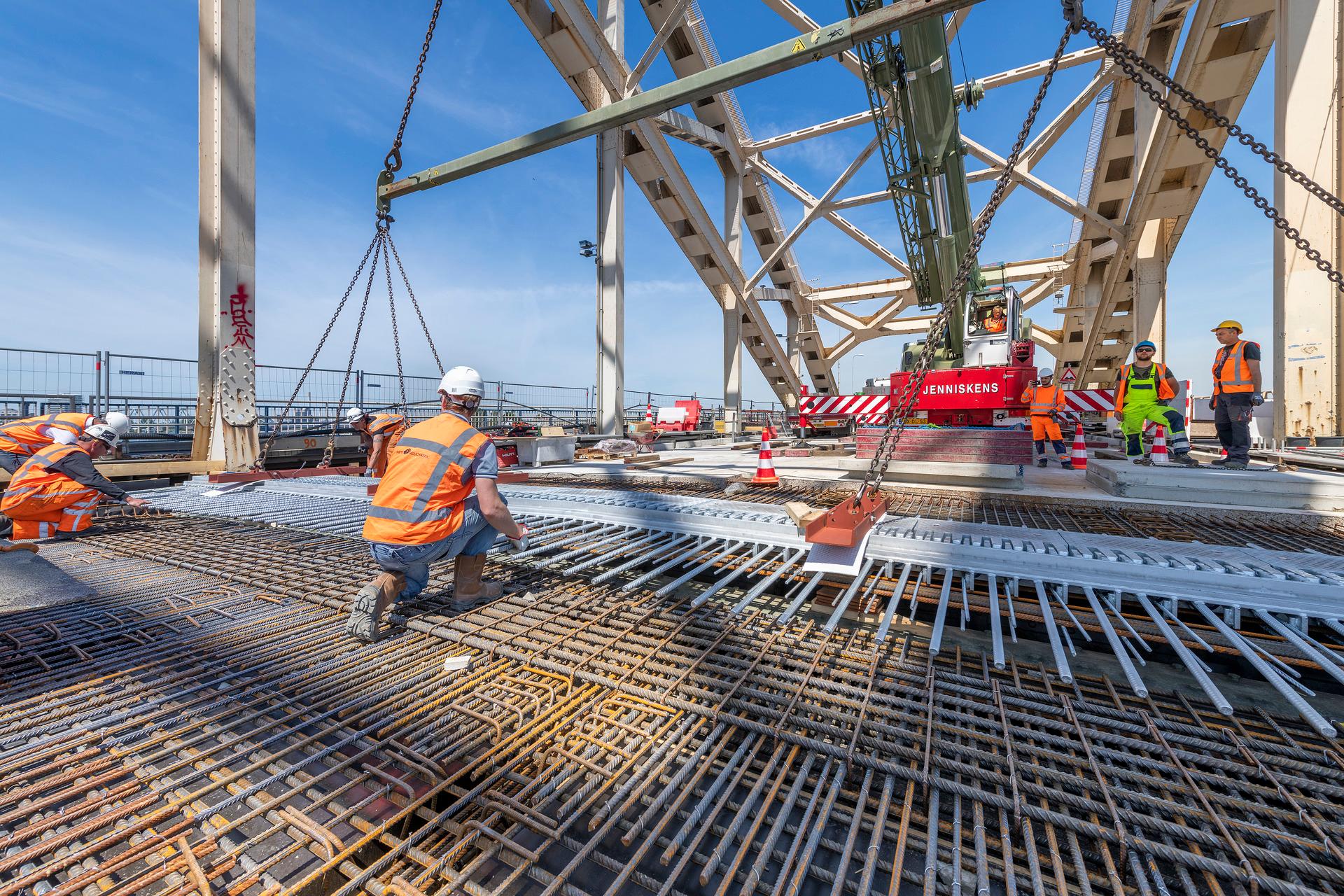Mensen aan het werk op een brug in beschermende kleding