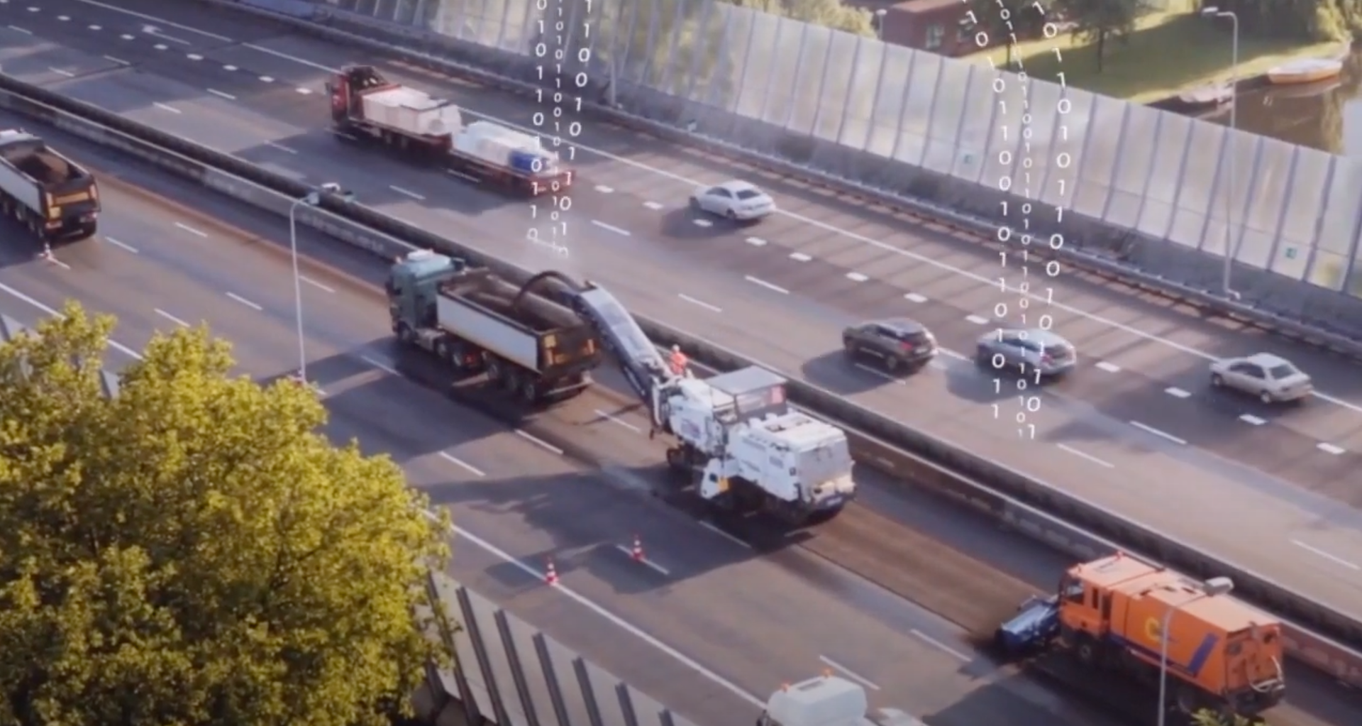 Een snelweg van bovenaf waar aan de weg wordt gewerkt. Een fictieve datastroom met nullen en enen stijgt op uit de weg