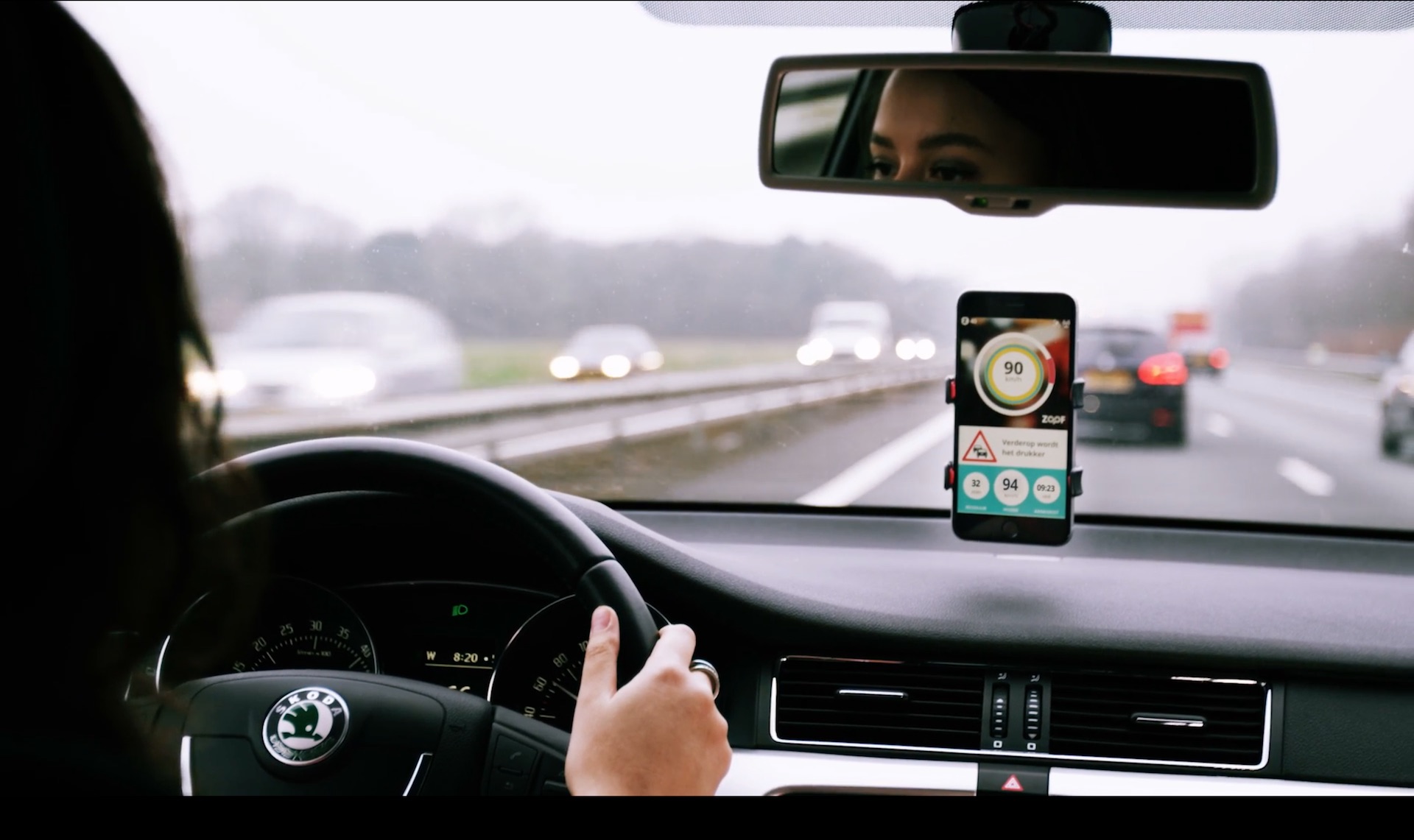 Een vrouw achter het stuur met navigatie op haar telefoon
