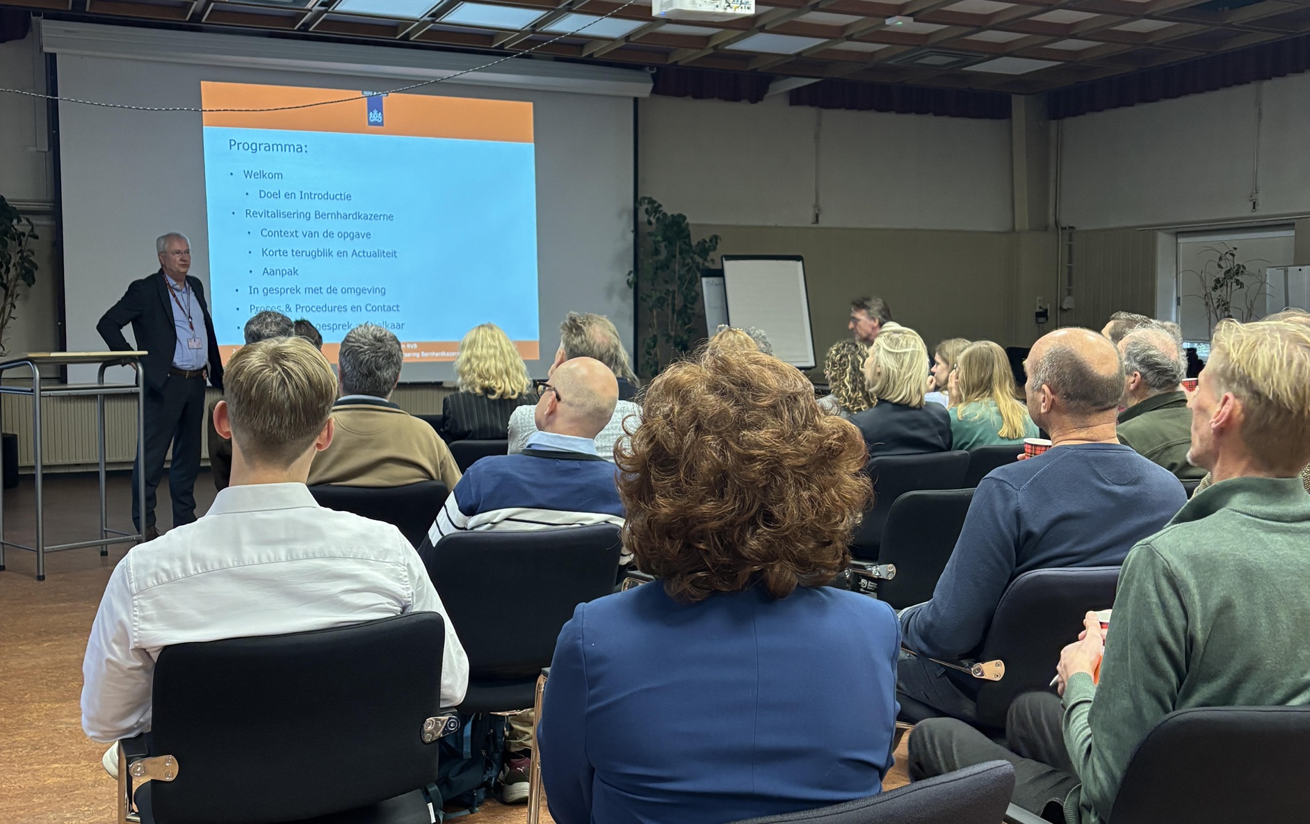 Foto groep mensen in zaal.