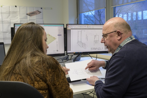 Jerry en Berber overleggen achter de computer. 