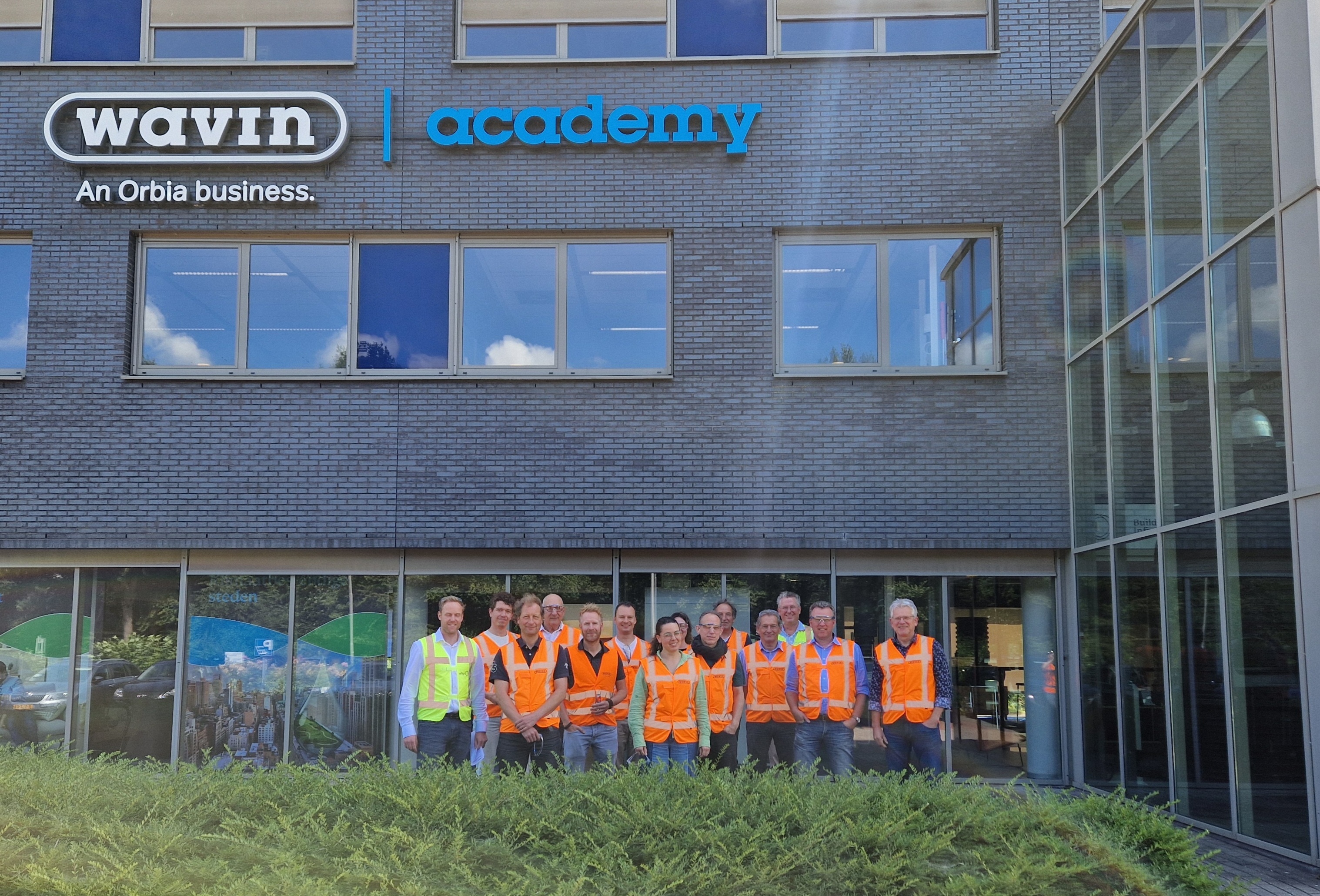 Werkbezoek bij Wavin: alle deelnemers voor het Wavin gebouw.